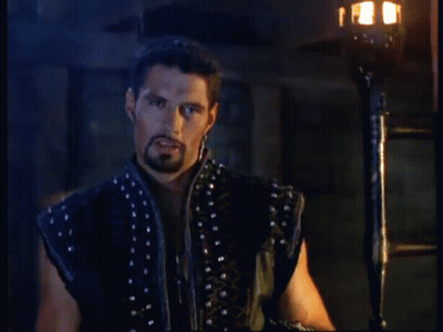 A Man With A Beard Is Standing In Front Of A Torch With The Words Still Picking Up On Me After All These Years Below Him GIF