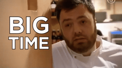 A Man With A Beard Is Standing In Front Of A Wall That Says Big Time GIF