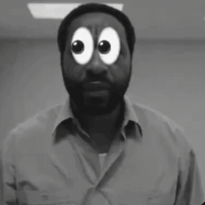 A Man With A Beard Is Standing In Front Of A Yellow Wall And Making A Funny Face . GIF