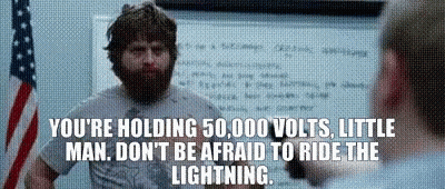 A Man With A Beard Is Standing In Front Of An American Flag And A White Board With A Quote On It GIF