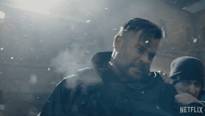 A Man With A Beard Is Standing In The Snow With A Netflix Logo In The Corner . GIF