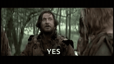 A Man With A Beard Is Standing In The Woods Talking To A Group Of People . GIF