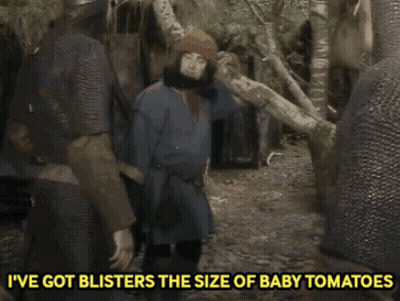 A Man With A Beard Is Standing In The Woods With The Words I 'Ve Got Blisters The Size Of Baby Tomatoes GIF