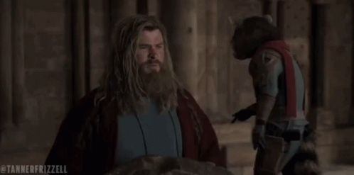 A Man With A Beard Is Standing Next To A Raccoon In A Costume . GIF