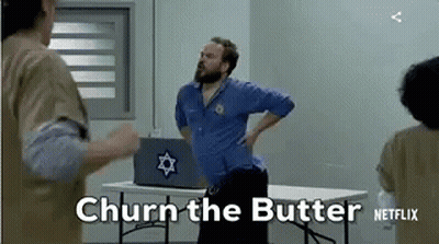 A Man With A Beard Is Standing Next To A Table With A Laptop On It . GIF