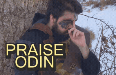 A Man With A Beard Is Standing Next To A Tree With The Words Praise Odin Written Above Him GIF