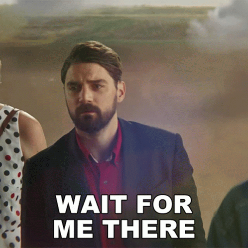 A Man With A Beard Is Standing Next To A Woman And Says Wait For Me There GIF