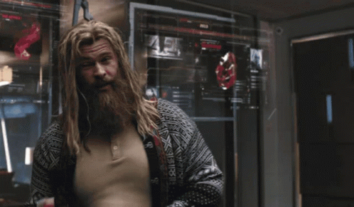 A Man With A Beard Is Standing Next To Another Man GIF
