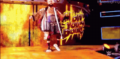 A Man With A Beard Is Standing On A Stage In Front Of A Wall That Says Low Your Doin 'S GIF