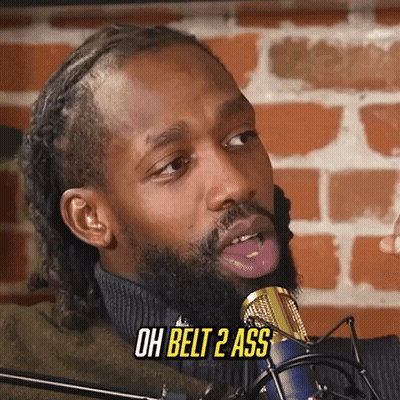 A Man With A Beard Is Sticking His Tongue Out In Front Of A Microphone And Says Oh Belt 2 Ass . GIF