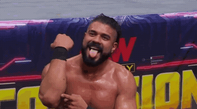 A Man With A Beard Is Sticking His Tongue Out In Front Of A Sign That Says Wrestling . GIF