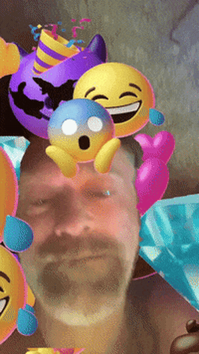 A Man With A Beard Is Surrounded By Balloons And Emojis GIF