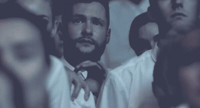 A Man With A Beard Is Surrounded By Other People In White Shirts GIF