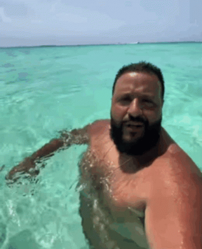 A Man With A Beard Is Swimming In The Ocean . GIF