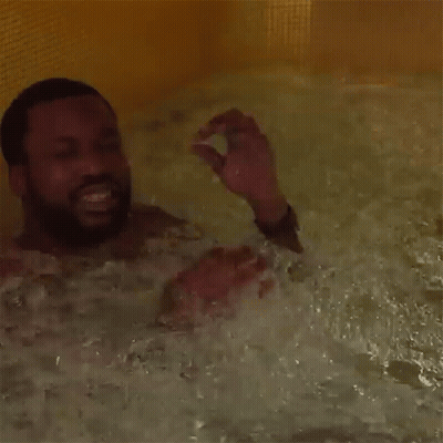 A Man With A Beard Is Taking A Bath In A Bathtub GIF