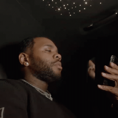 A Man With A Beard Is Taking A Picture Of Himself In A Mirror With His Cell Phone . GIF