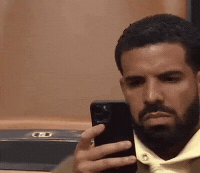 A Man With A Beard Is Taking A Picture Of Himself With His Phone . GIF