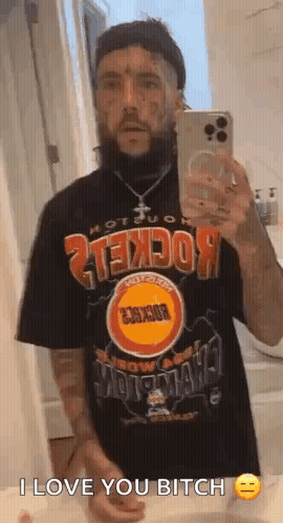 A Man With A Beard Is Taking A Selfie In A Bathroom Mirror . GIF