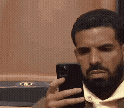 A Man With A Beard Is Taking A Selfie With A Cell Phone . GIF