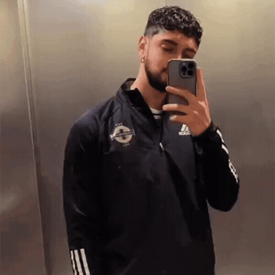 A Man With A Beard Is Taking A Selfie With His Cell Phone . GIF