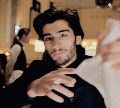 A Man With A Beard Is Taking A Selfie With His Phone GIF