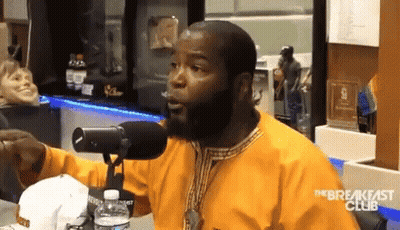 A Man With A Beard Is Talking Into A Microphone With The Breakfast Club Written On The Bottom GIF