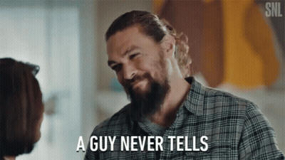 A Man With A Beard Is Talking To A Woman And Says " A Guy Never Tells " GIF