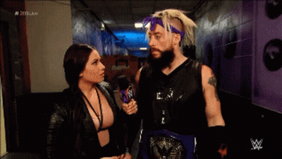 A Man With A Beard Is Talking To A Woman In A Hallway . GIF
