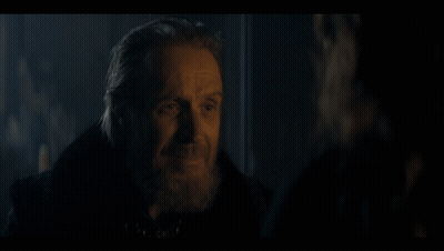 A Man With A Beard Is Talking To Another Man In A Dark Room . GIF