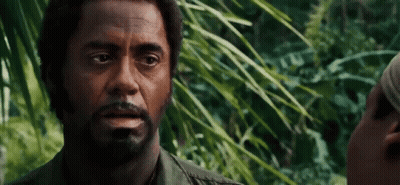 A Man With A Beard Is Talking To Another Man In A Forest . GIF