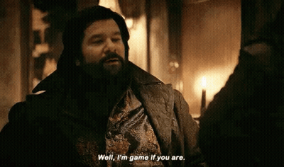 A Man With A Beard Is Talking To Another Man In A Room With A Candle . GIF