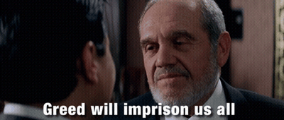 A Man With A Beard Is Talking To Another Man With Greed Will Imprison Us All Written Below Him GIF