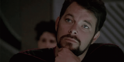 A Man With A Beard Is Thinking And Pointing To His Chin . GIF