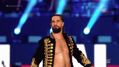 A Man With A Beard Is Walking On A Stage Without A Shirt On . GIF