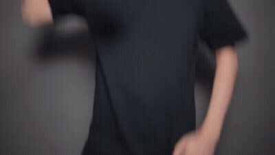 A Man With A Beard Is Waving His Hand In Front Of A Gray Background . GIF