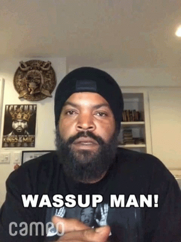 A Man With A Beard Is Wearing A Beanie And A Shirt That Says Wassup Man Cameo GIF