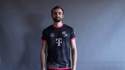 A Man With A Beard Is Wearing A Black And Pink Shirt With The Letter T On It GIF