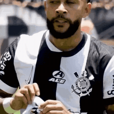 A Man With A Beard Is Wearing A Black And White Shirt That Says Ale GIF
