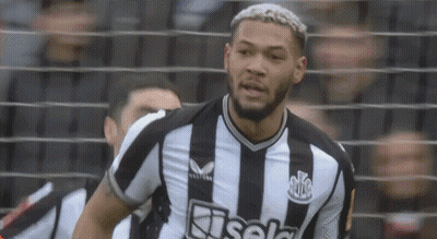 A Man With A Beard Is Wearing A Black And White Striped Shirt . GIF