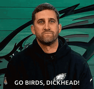 A Man With A Beard Is Wearing A Black Hoodie And Says `` Go Birds , Dickhead '' . GIF