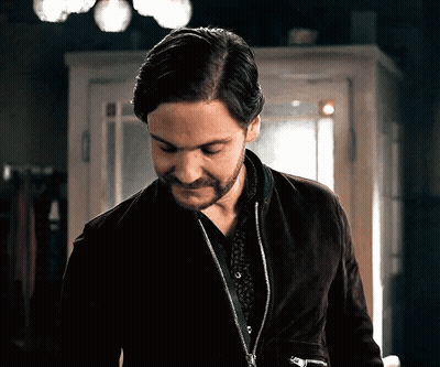 A Man With A Beard Is Wearing A Black Jacket And A Black Shirt GIF