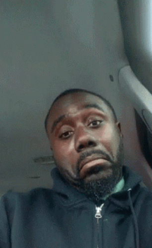 A Man With A Beard Is Wearing A Black Jacket With A Zipper On The Front GIF