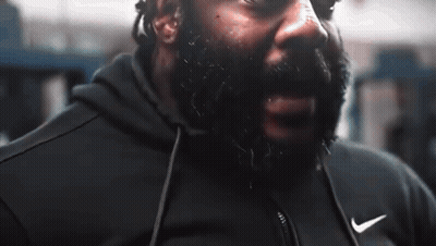 A Man With A Beard Is Wearing A Black Nike Jacket GIF