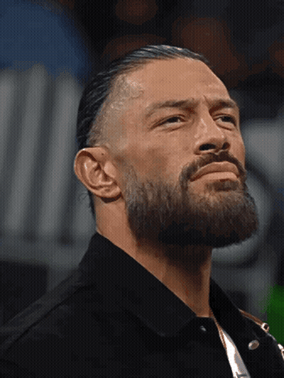 A Man With A Beard Is Wearing A Black Shirt And A Black Jacket GIF