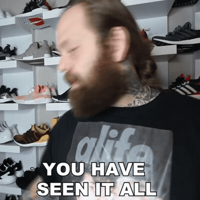 A Man With A Beard Is Wearing A Black Shirt That Says Alife GIF