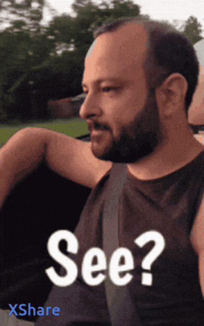 A Man With A Beard Is Wearing A Black Shirt That Says See On It GIF