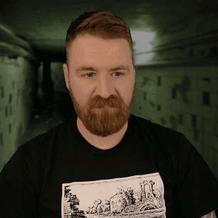 A Man With A Beard Is Wearing A Black Shirt With A Drawing Of A House On It GIF