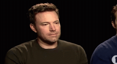 A Man With A Beard Is Wearing A Black Shirt With The Letter T On It GIF