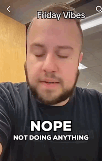 A Man With A Beard Is Wearing A Black Shirt With The Words Friday Vibes Nope Not Doing Anything On It . GIF