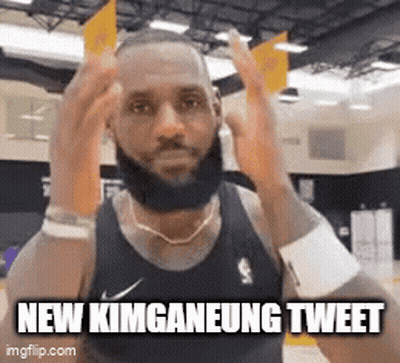 A Man With A Beard Is Wearing A Black Tank Top And Making A Face . GIF